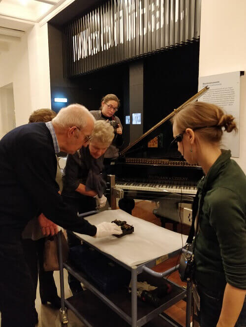Geschichte „hautnah“ erleben Sehbeeinträchtigter Mann tastet mit der rechten Hand ein technisches Gerät ab, er trägt dabei einen weißen Baumwollhandschuh.