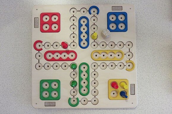 Der beliebte Klassiker „Mensch ärgere dich nicht“. Taktiles Mensch ärgere dich nicht Brett mit bunten Figuren.