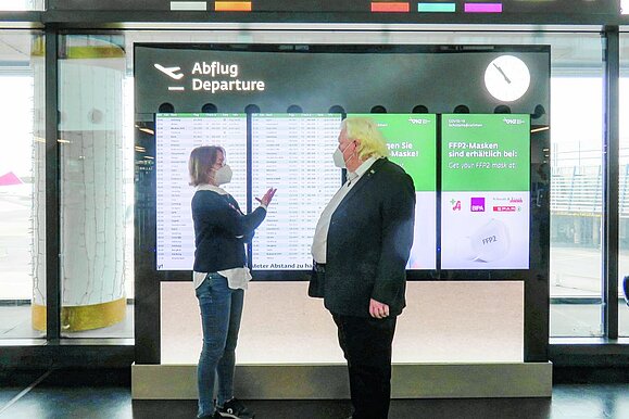 Redakteurin Andrea Ferstel nahm sich viel Zeit. Prof. Dr. Elmar Fürst steht mit Frau vor Abflugtafel.