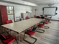 Konferenzraum mit Whiteboard und langer Tafel