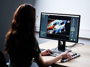 Imagebild aus dem Projekt OptiVID. Fotocredits: AIT/Wolf Frau betrachtet Computerbildschirm, auf dem die Optimierungssoftware OptiVID geöffnet ist.