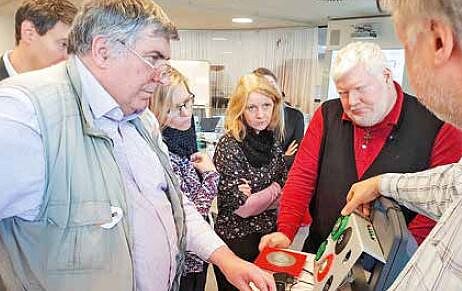 Mehrere Menschen schauen auf technisches Gerät