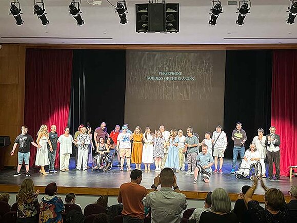 Schauspieler sind auf einer Bühne bei der Aufführung eines Theaterstücks zu sehen.